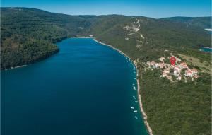 an island with a red house in the middle of a lake at Apartment Labin Lxxxi in Labin