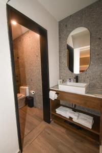 ein Badezimmer mit Waschbecken und Spiegel in der Unterkunft Expo Satélite 2750 Hotel & Suites in Guadalajara