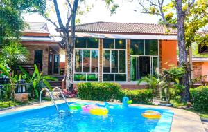 a swimming pool in front of a house at Phalaburi resort by dreamhouse in Ban Phala