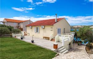 a house with a patio and a yard at 2 Bedroom Awesome Apartment In Stara Novalja in Stara Novalja