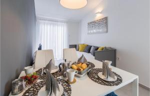 ein Esszimmer mit einem weißen Tisch mit Obst darauf in der Unterkunft Apartment Korculanska Croatia in Poreč