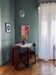 a dining room table with a vase of flowers on it at Luxury Nile View Apartment in Cairo