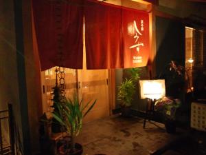 a room with red curtains and plants and a lamp at Ryokan Shimizu in Kyoto
