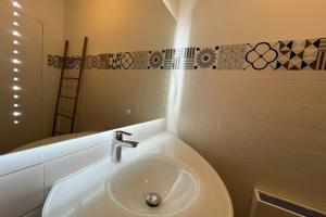 a bathroom with a sink and a toilet and a mirror at Spacieux appartement proche des halles Wifi in Narbonne +13 photos
