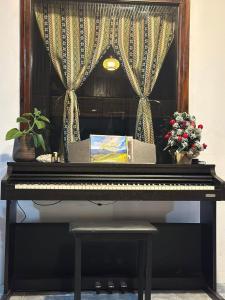 Yen BaiNamora House KG Giao Hưởng的钢琴,窗户上放着鲜花