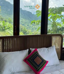 Yen BaiNamora House KG Giao Hưởng的窗户前的一张带白色枕头的床