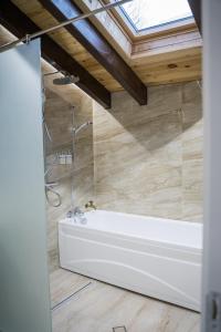 a bath tub in a bathroom with a skylight at Хотелски комплекс Релакс in Rudozem