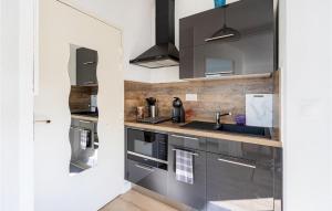 a kitchen with gray cabinets and a sink at Awesome Apartment In Hyères With Wifi in Hyères
