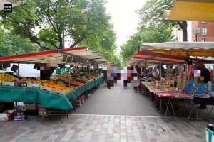 a market with several tables filled with fruits and vegetables at Charme apt a Paris ideal for 3p in Paris
