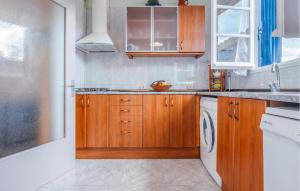 a kitchen with wooden cabinets and white appliances at Awesome Home In Sant Miquel De Fluvià in San Miguel de Fluviá