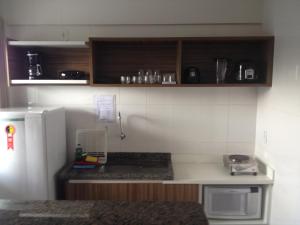a kitchen with a white refrigerator and wooden cabinets at Lacqua diRoma in Caldas Novas