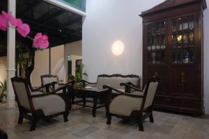 a dining room with chairs and a table and a cabinet at Agung Guest House by RF in Yogyakarta