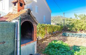 un horno de ladrillo en un patio junto a una casa en Lovely Apartment In Poljica With Wifi, en Poljica