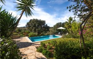 a swimming pool in the middle of a garden at Lovely Home In Porto Cristo in Porto Cristo