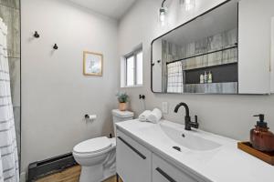 a white bathroom with a toilet and a sink at Canyon Retreat with Hot Tub 3min to Broadmoor in Colorado Springs +47 photos
