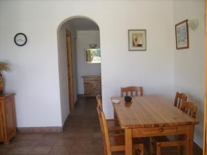 a dining room with a wooden table and chairs at Villa Isabel in Cala'n Bosch