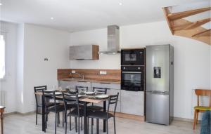 a kitchen with a table and chairs and a refrigerator at Awesome Home In Canihuel in Canihuel