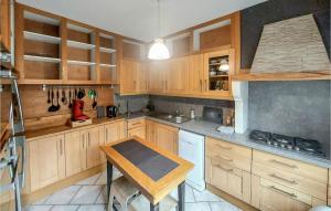 eine Küche mit Holzschränken und einem Holztisch in der Unterkunft Stunning Home In Grand-Fort-Philippe in Grand-Fort-Philippe