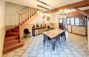 eine Küche mit einem Tisch und Stühlen sowie eine Treppe in der Unterkunft Stunning Home In Grand-Fort-Philippe in Grand-Fort-Philippe
