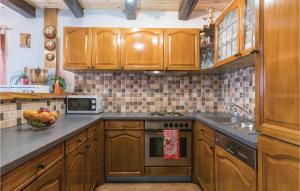 une cuisine avec des armoires en bois et un évier dans l'établissement Four-Bedroom Holiday Home In Velika Buna, à Velika Buna