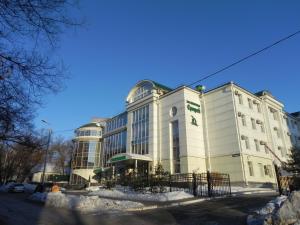 a large white building with snow in front of it at Hotel Erofey in Khabarovsk