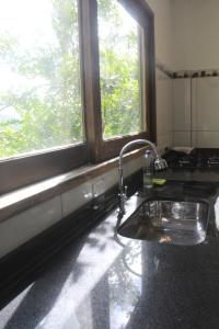 a kitchen with a sink and two windows at sunshine home in Paraty +39 photos