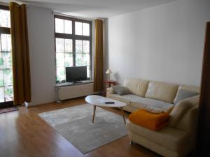 a living room with a couch and a table at Zum Senckenberg by Satischni in Görlitz