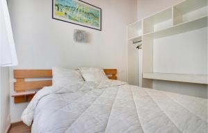 a bedroom with a white bed and a window at Cozy Home In La Faute-Sur-Mer in La Faute-sur-Mer