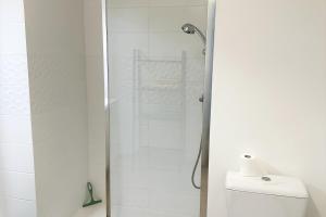 a shower with a glass door next to a toilet at Studio Récent Prés d'Arènes Terrasse Wifi parking privé in Montpellier