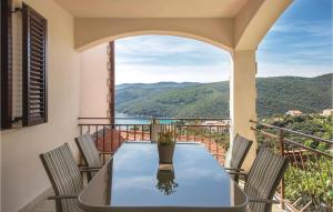 a table and chairs on a balcony with a view at Two-Bedroom Apartment In Rabac in Rabac