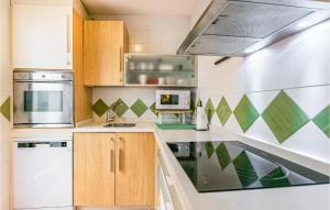 a kitchen with white and green tiles on the wall at 2 Bedroom Lovely Apartment In Cordoba in Córdoba