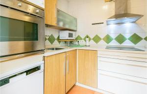 a kitchen with wooden cabinets and stainless steel appliances at 2 Bedroom Lovely Apartment In Cordoba in Córdoba
