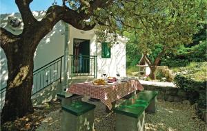 a table and bench in front of a house with a tree at Holiday Home Gornje Tucepi With Fireplace Vii in Tučepi