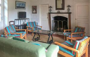 un soggiorno con divano, poltrone e camino di Nice Home In La Boissière Des Lande a La Boissière-des-Landes