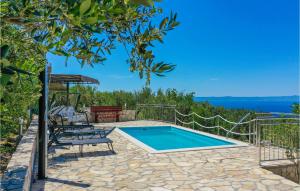 a swimming pool with two chairs and a table at Holiday Home Bast 30 in Bast