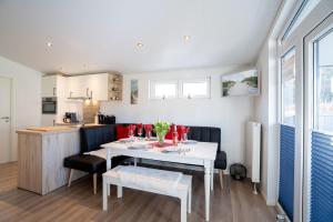 a dining room and kitchen with a white table and chairs at Casa del Sol Scharbeutz - Sauna kostenlos - 1 kleiner Hund willkommen - umzäunter Garten in Scharbeutz +18 photos
