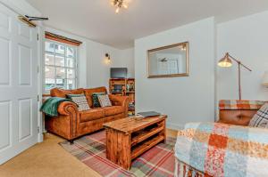 a living room with a couch and a table at Jacobite's Retreat, 17th century cottage in the heart of Inverness in Inverness