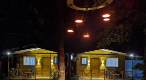 a couple of small wooden buildings at night at WOODMOOD Cottages in Chapora