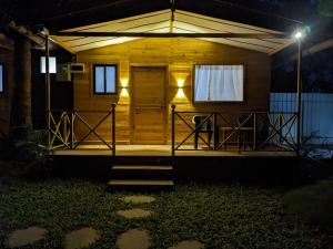 a front porch of a wooden house at night at WOODMOOD Cottages in Chapora