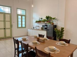 a kitchen and dining room with a wooden table and chairs at Kaba Home Melaka in Malacca