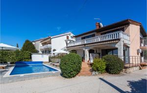 a house with a swimming pool in front of it at Cozy Apartment In Punat With Sauna in Punat +19 photos