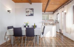 a kitchen and dining room with a white table and chairs at Cozy Apartment In Punat With Sauna in Punat
