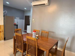 a dining room with a wooden table and chairs at L23 ,88 Resort Villa House in Pangkor