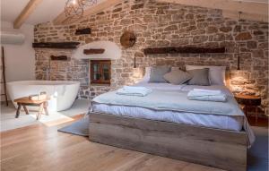 sypialnia z dużym łóżkiem i kamienną ścianą w obiekcie Awesome Home In Bale With Wifi w mieście Bale