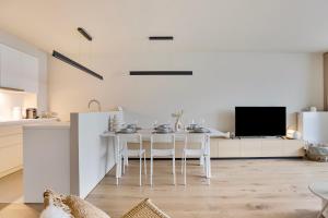 a kitchen and dining room with a table and chairs at Premium Holidays - New design flat near the beach of Nieuwpoort in Nieuwpoort