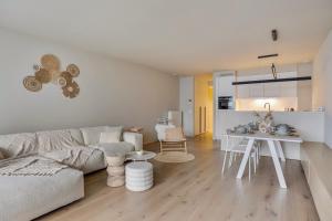 a living room with a white couch and a table at Premium Holidays - New design flat near the beach of Nieuwpoort in Nieuwpoort