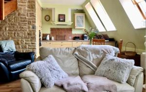 een woonkamer met een witte bank met kussens erop bij Apartament Pers - przytulny, klimatyzowany, z kominkiem i bezpłatnym parkingiem in Szczawno-Zdrój