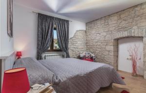 sypialnia z łóżkiem i kamienną ścianą w obiekcie Nice Home In Krsan With Kitchen w mieście Kršan +37 zdjęć