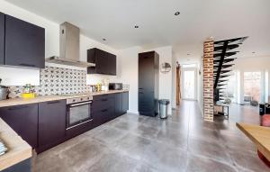 a kitchen with black cabinets and a tile floor at 3 Bedroom Beautiful Home In Charnois in Charnois