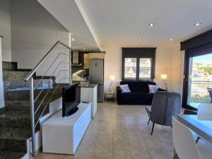 a living room with a tv and a couch at Duplex Univers - Frente al mar in L'Escala